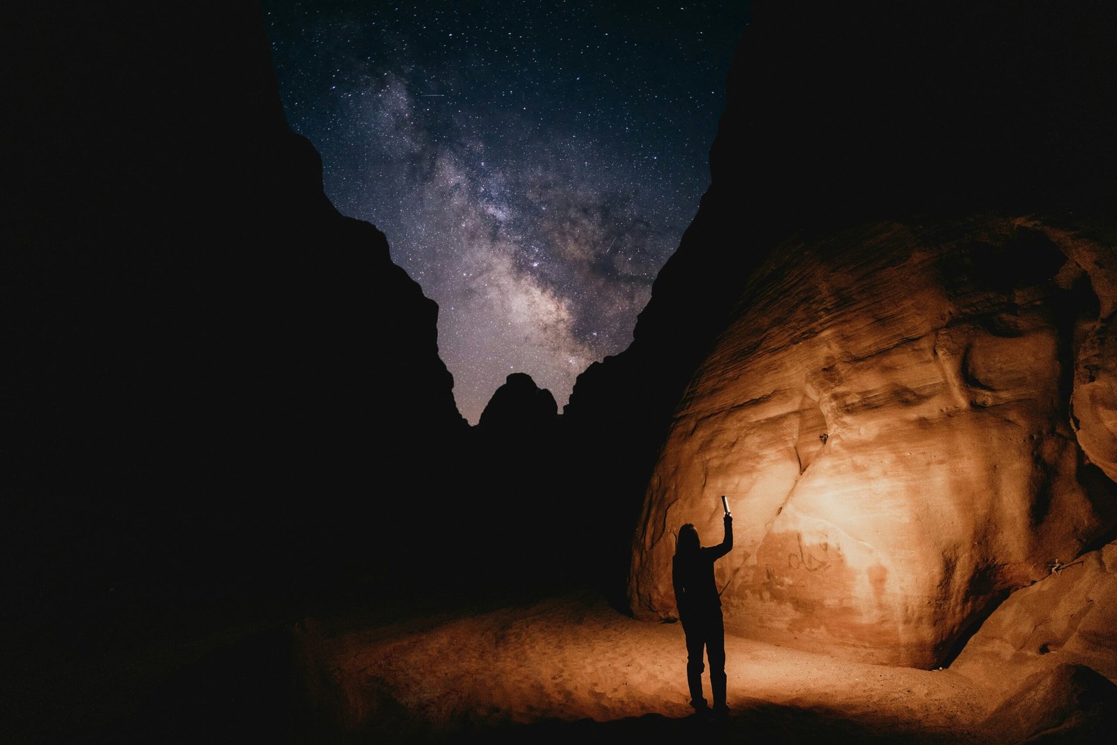 a man standing in the middle of a desert at night